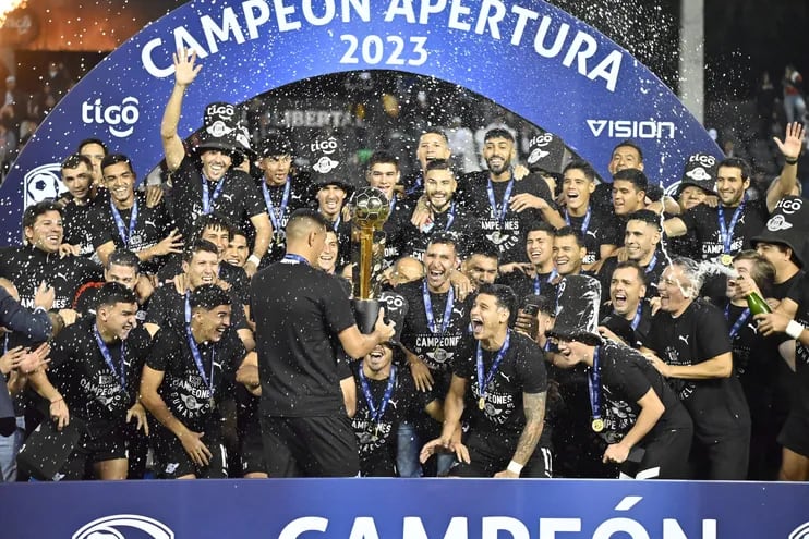 Los jugadores de Libertad celebran con el trofeo de campeón del torneo Apertura 2023 del fútbol paraguayo.