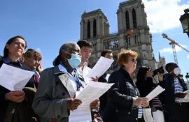 Catholic faithfuls attend a prayer gathering on the square in front of the Notre-Dame cathedral in Paris on April 15, 2022, to mark the third anniversary of a fire that partially destroyed the cathedral. (Photo by Bertrand GUAY / AFP)