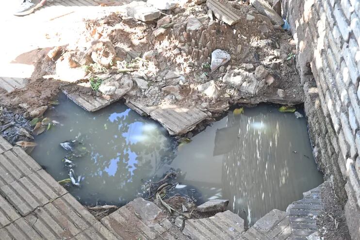Un pozo acumula una gran cantidad de agua servida, o cloaca, en una vereda del barrio Obrero de Asunción. Los alumnos de la escuela que está al lado, deben almorzar con el fétido olor que despiden las aguas negras.