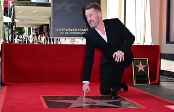 El actor estadounidense Macaulay Culkin hace un gesto cerca de su recién inaugurada estrella del Paseo de la Fama de Hollywood en Hollywood, California, el 1 de diciembre de 2023.