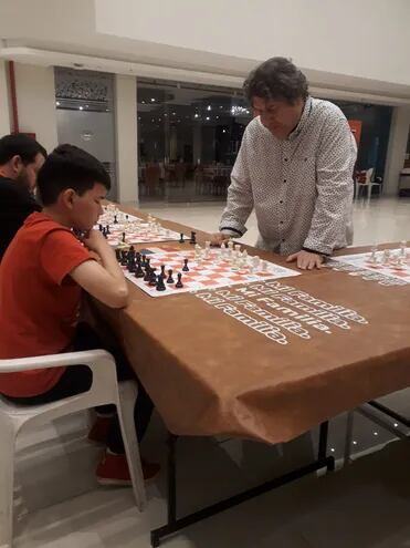 Maximiliano Ibáñez y el Gran Maestro de ajedrez, Zenón Franco, durante su partida ayer en Sajonia, Asunción.