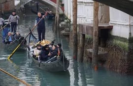 Gondoleros reman con cuidado en el río Santa María Formosa debido a la excepcional marea baja que ha registrado 70 centímetros bajo el nivel del mar, en Venecia, Italia.