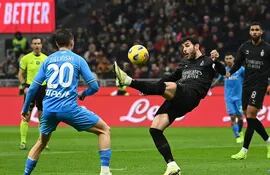 El francés Theo Hernández, capitán del AC Milan, intenta dominar el balón ante la presencia del polaco Piotr Zieliński, centrocampista del Napoli, durante el partido disputado ayer