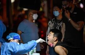Trabajadores de la salud realizan test de covid en la localidad de Huangpu, distrito de Shanghai. (AFP)