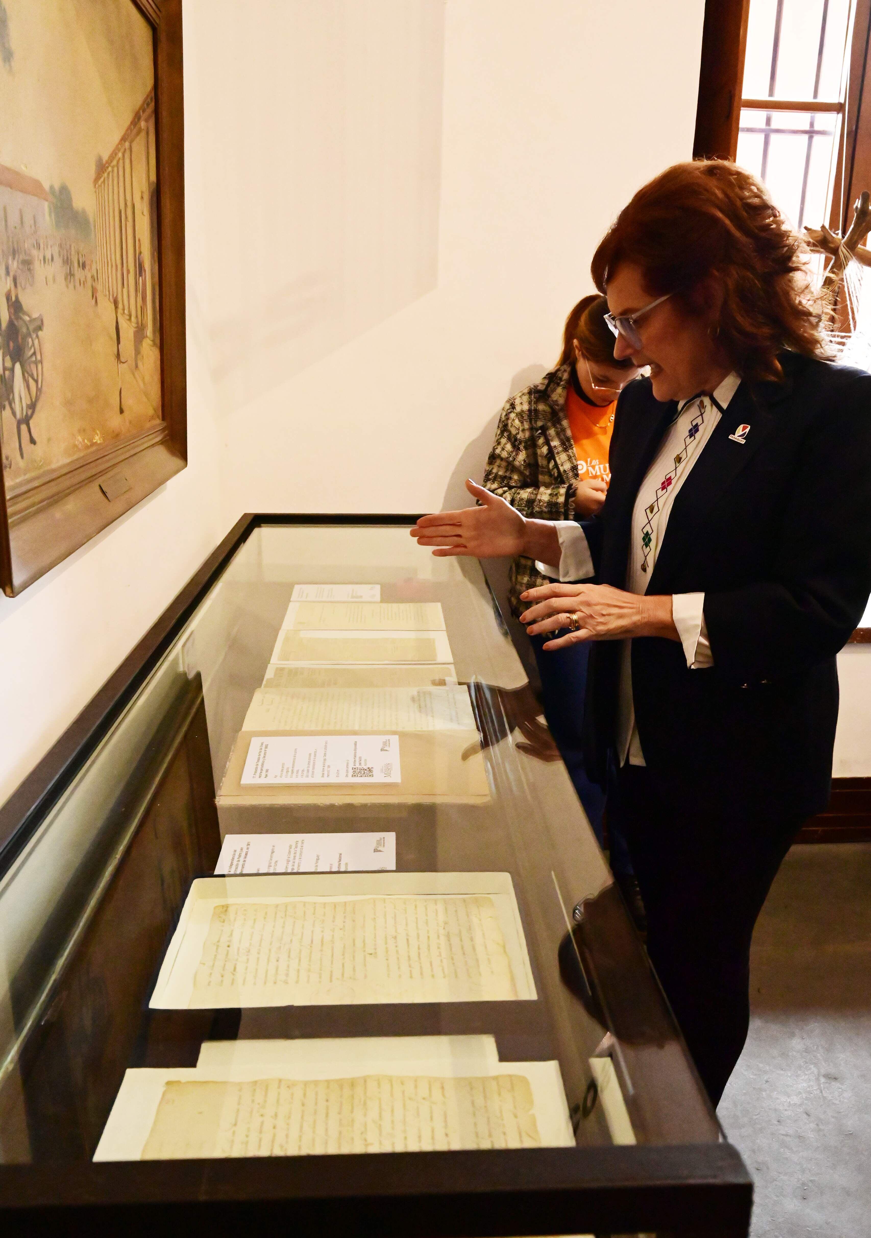 Gloria Velilla muestra la vitrina donde se exhiben valiosos documentos de nuestra historia como la nota del 20 de julio y el tratado de paz de la Guerra del Chaco.