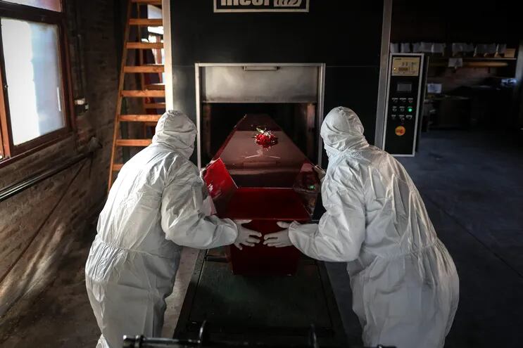 Trabajadores de un crematorio preparan un féretro en un cementerio de Luján, en la provincia de Buenos Aires.
