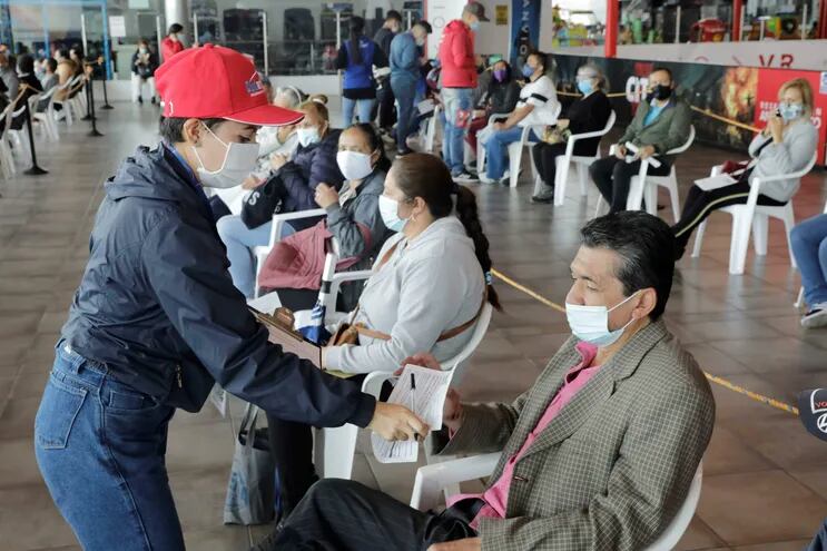 Personal de asistencia registra a un grupo de personas que recibirá la vacuna contra la covid-19 hoy, en el Mallplaza, uno de los centros comerciales habilitados como punto de vacunación masiva, en Bogotá (Archivo).