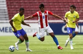 El jugador de Brasil Rayan Simplicio (i) disputa el balón con Paulo Riveros (c) de Paraguay hoy, en un partido del Sudamericano Sub-17 en el estadio Rodrigo Paz en Quito (Ecuador).