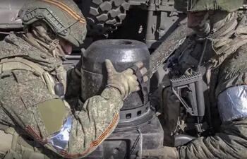 Fotografía cedida por el Ministerio de Defensa de Rusia en la que se observa a soldados rusos inspeccionar un misil antitanque abandonado por las ucranianas en la región separatista de Donetsk, Ucrania. (EFE/EPA)
