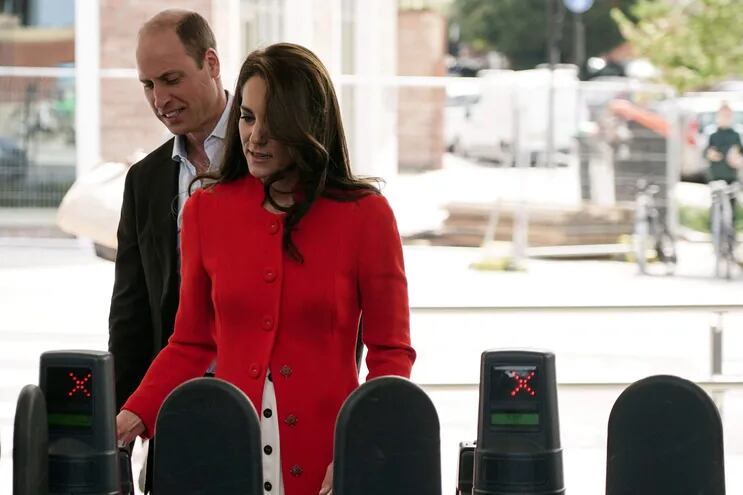 El príncipe Guillermo y su esposa Kate validan una entrada al metro de Londres, medio de transporte que utilizaron para llegar a un pub londinense.