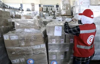 Un voluntario de la Media Luna Roja inspecciona contenedores de ayuda humanitaria para Gaza, almacenada en Arish, Egipto, este miércoles.