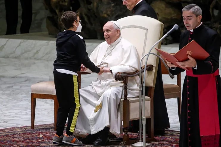 El joven Paolo Junior, de 10 años, se acerca al papa Francisco (c) durante su audiencia general de los miércoles en el Aula Pablo VI en la Ciudad del Vaticano, este miércoles.
