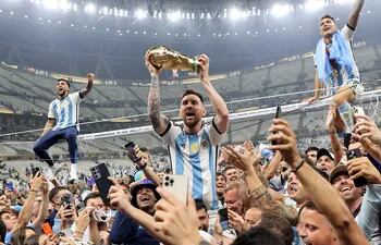 Lionel Messi (c) alza el trofeo del campeones del Mundial de Qatar 2022 después de que Argentina se impusiera a Francia en la final celebrada en el Lusail stadium, el 18 de diciembre.