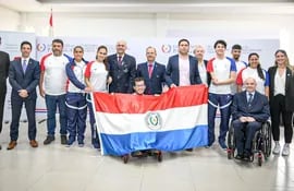 Iván Cáceres, el abanderado de Paraguay, posa con la tricolor junto a los paraatletas, entrenadores y dirigentes al finalizar el acto de abanderamiento.