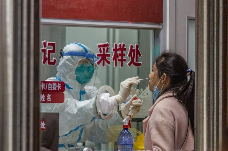 Un personal sanitario toma una muestra para covid, en Shanghai, China.