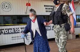 Agapita González (81), acompañada de Rober, miembro de la Armada paraguaya cruzando al frontera entre Encarnación-Posadas.