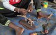 Un hombre termina de confeccionar los adornos que van cosidos a un zapato de neumático en el mercado Konyo Konyo en Yuba. Les dicen "mutu kelei", lo que en el dialecto árabe de Yuba significa "morirás y ellas seguirán", zapatillas hechas a partir de neumáticos viejos que se han convertido en una solución económica y tan dura como la vida en Sudán del Sur, pero con un encanto y estilo particulares.