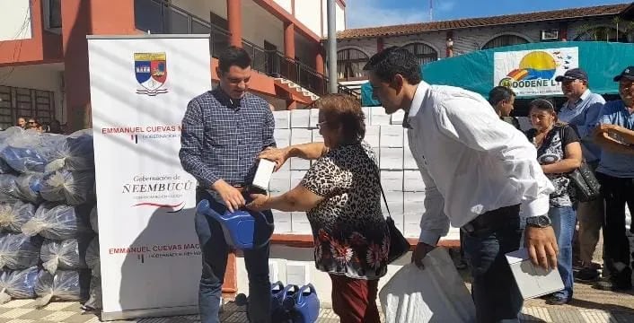 El gobernador de Ñeembucú entrega el primer insumo de hortalizas a la Sra. Bartola Barrios del barrio San Roque de Pilar, ayuda con el abono el ingeniero Víctor Quintana.