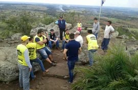 Integrantes de la Asociación de Jóvenes por Capiibary reunidos sobre el Cerro dos de Oro proyectando los trabajos en el lugar.