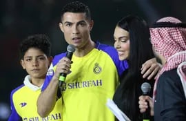 El delantero portugués Cristiano Ronaldo y su pareja Georgina Rodríguez. A la derecha, su hijo Cristiano Ronaldo Jr saludan a la multitud en el estadio Mrsool Park, en Riad.