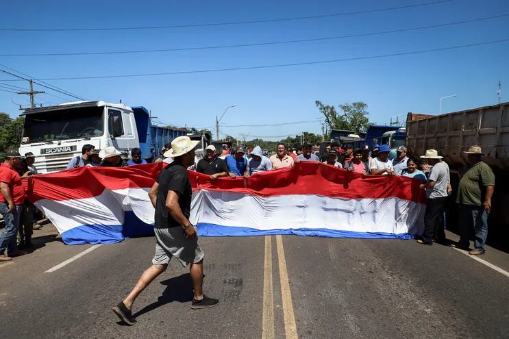 Camioneros protestan sobre la Ruta 3, hoy en la ciudad de Limpio (Paraguay). Paraguay cumple el cuarto día de manifestaciones en distintas vías, pese al anuncio de la estatal petrolera de reducir a partir de hoy el precio de dos de los carburantes de mayor uso en el país. Los manifestantes, en su mayoría camioneros, consideran insuficiente la rebaja y amenazan con ampliar los intervalos en los que obstaculizan el paso por las carreteras. EFE/Nathalia Aguilar