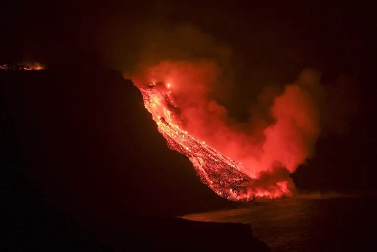 La colada de lava que emerge de la erupción volcánica de La Palma ha llegado en la noche del martes al mar en una zona de acantilados situados en las cercanías de la playa El Guirre, en Tazacorte. EFE/Ángel Medina