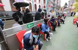Varios ciudadanos esperan en un punto de vacunación autorizado para recibir una dosis de refuerzo de la vacuna contra la COVID-19, en La Paz.