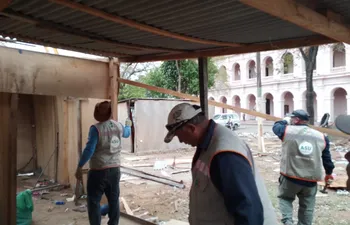 Varios trabajadores municipales proceden a desarmar las casas precarias de terciada y chapa que están frente a El Cabildo. (Fuente Twitter).