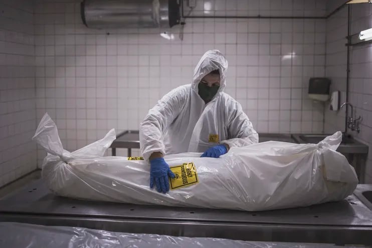 Un empleado de una morgue en Pretoria, Sudáfrica, prepara el cuerpo de un paciente fallecido por covid-19.