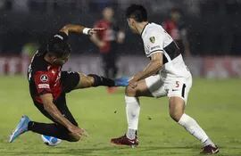 Saúl Salcedo (i), defensor de Olimpia, disputa un balón con Facundo Tomás Garcés, de Colón de Santa Fe, durante el duelo de la Copa Libertadores en el estadio Defensores del Chaco.