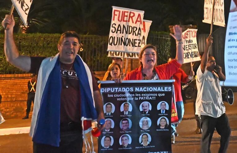 Manifestantes sostienen carteles contra diputados liberales que ayudaron a Sandra Quiñónez.