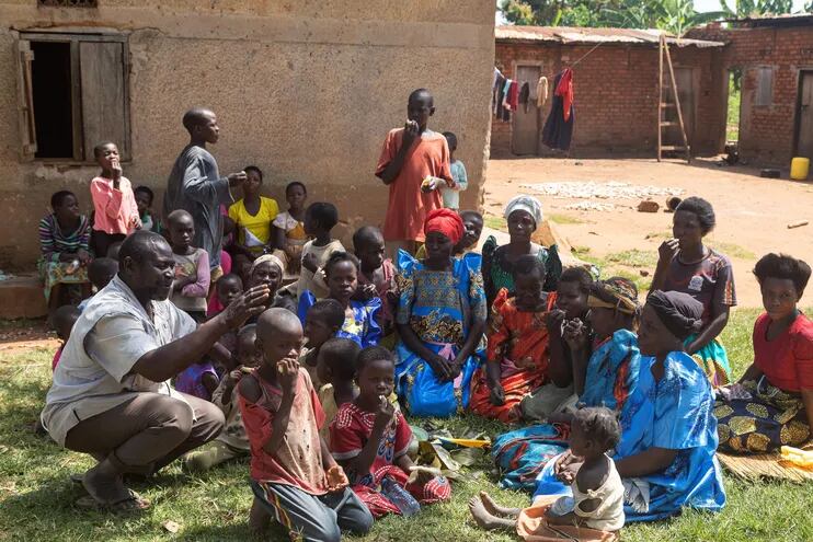 El ugandés Musa Hasahya (i) conversa con algunos de sus 102 hjijos y algunas de sus 12 esposas, en Butaleja, en Uganda.  (AFP)