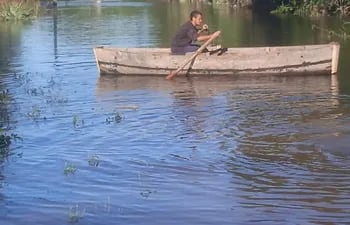 Un nativo cruzando en un "cachiveo" en una zona inundada, los cachiveos son botes usados para salir del aislamiento y son hechos de samu´u.
