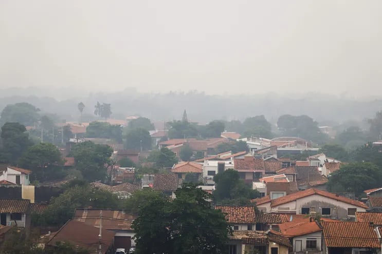 AME9308. AASUNCIÓN (), 28/02/2022.- Vista de un barrio de la capital cubierto por una nube de humo hoy en Asunción (Paraguay). Asunción y otras localidades de Paraguay fueron afectadas este lunes por una nube de polvo y cenizas producto de los incendios forestales que se formó en medio de un temporal. EFE/Nathalia Aguilar
