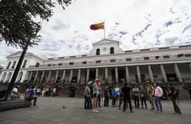 Ciudadanos ecuatorianos caminan a las afueras del Palacio de Gobierno hoy, en Quito (Ecuador).