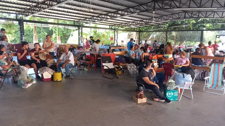 Familiares sufren del intenso calor bajo el techo de chapa del albergue del IPS.