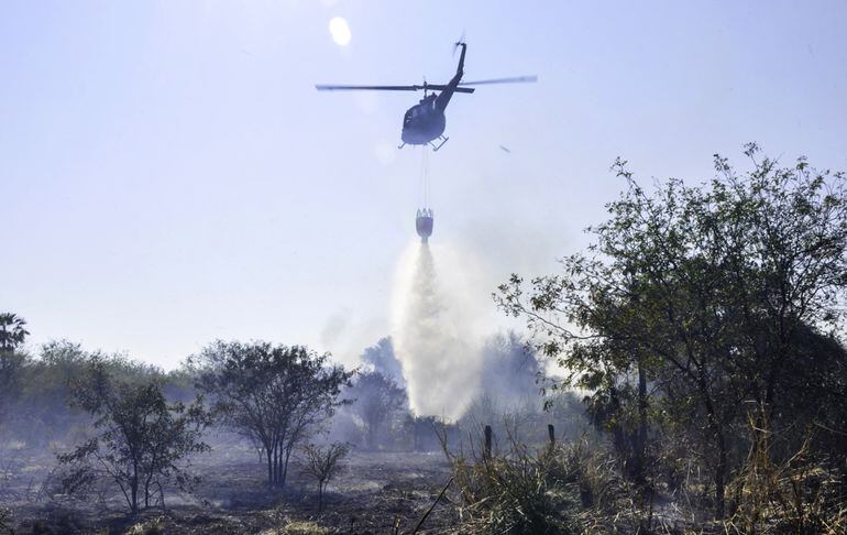 Desde un helicóptero Bambi arrojan agua sobre un foco de incendio en la zona de Bahía Negra. La situación es desesperante.