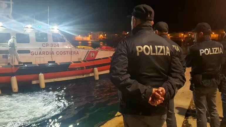 Policías en el muelle del puerto esperan la embarcación con los cuerpos de 8 migrantes en Lampedusa, Sicilia, Italia, 03 de febrero de 2023.