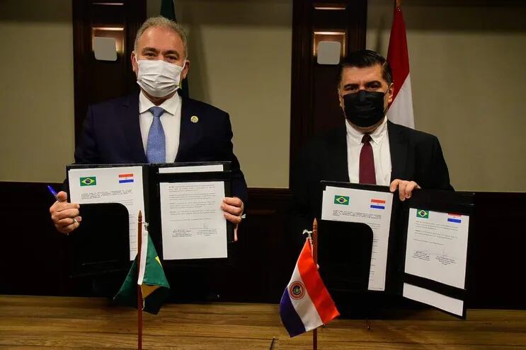 Los ministros de Salud, Marcelo Queiroga (Brasil) y Julio Borba (Paraguay) muestran el acuerdo de vigilancia sanitaria firmado durante un encuentro en Foz de Yguazú.