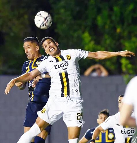 Lucas Barrios y Marcos Cáceres intentan conectar el balón con la cabeza. Un duelo constante dentro del área.