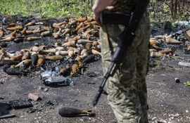 Un soldado ucraniano observa decenas de minas desarmadas después de que el ejército ruso dejó el lugar tras un mes de ocupación, en la población de Mala Rohan.