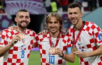 Mateo Kovacic (i), Luka Modric  e Iván Perisic exhiben orgullosos sus medallas de bronce del Mundial de Qatar 2022, que conquistaron ayer tras vencer a Marruecos en el partido por el tercer puesto.