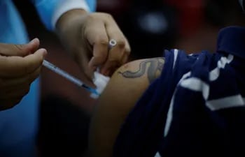 Un joven recibe su primera dosis de vacuna contra el covid-19 en San Salvador.