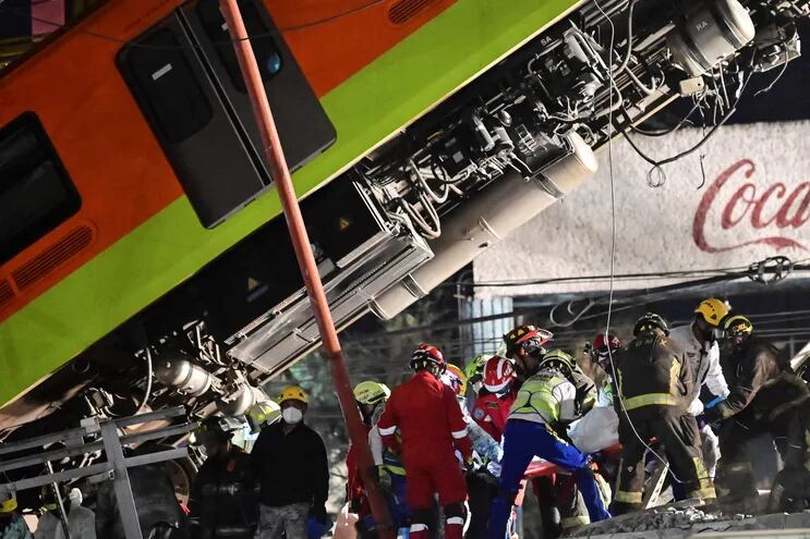 Los rescatistas retiran un cuerpo de un vagón de tren después de que una línea elevada del metro colapsara en la Ciudad de México.
