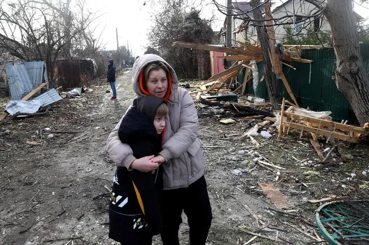 Residentes locales se encuentran entre los escombros en la calle frente a una casa destruida como resultado de un ataque con drones en la región de Odesa.