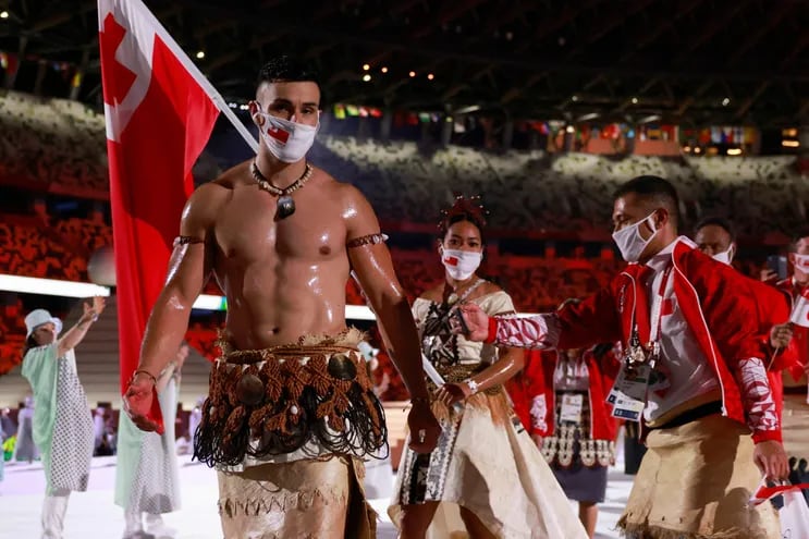 Tonga's flag bearers Pita Taufatofua (L) and Malia Paseka  (2L)  lead their delegation as they parade  during the opening ceremony of the Tokyo 2020 Olympic Games, at the Olympic Stadium, in Tokyo, on July 23, 2021. (Photo by Odd ANDERSEN / AFP)