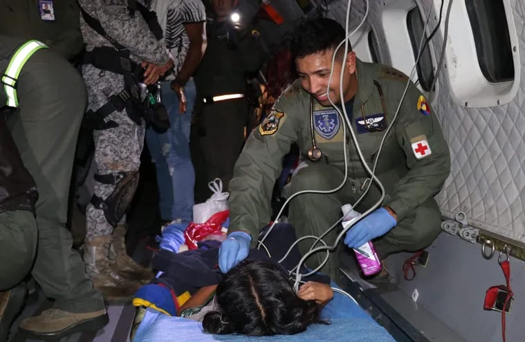 Un rescatista militar colombiano revisa a bordo de un avión a una de las niñas perdidas en la selva por cuarenta días. Ahora los cuatro chicos se recuperan en un hospital, y se estudia su futuro, luego de que sean dados de alta.