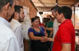 Santi Peña acompañado del Gobernador Juan Carlos Baruja, el Intendente Marcelo Simbrón, saludando a una trabajadora del mercado