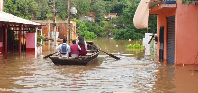 Escolares salieron de las zonas inundadas en canoa para asistir a clases este lunes.
