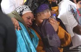 Familiares lloran ante los ataúdes de las 21 jóvenes víctimas que fallecieron tras una fiesta extraescolar  en Enyobeni Tavern, Sudáfrica.